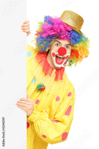 Funny circus clown holding a blank panel