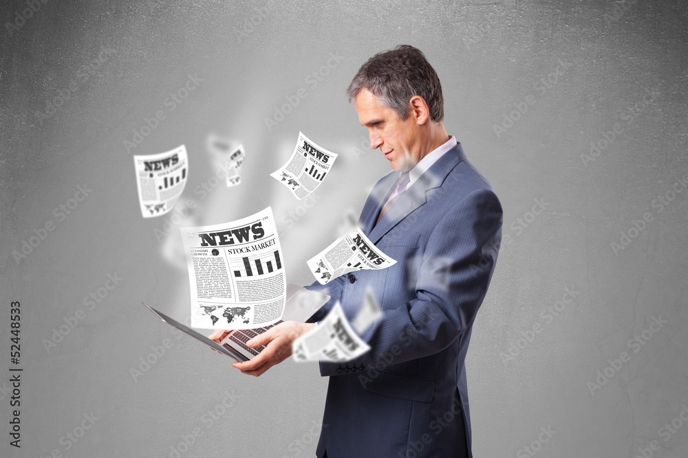 Middle aged businessman holding notebook and reading the explosi Middle aged businessman holding notebook and reading the explosi