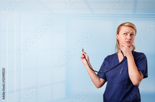 Pretty nurse in hospital listening to empty copy space with sthe photo