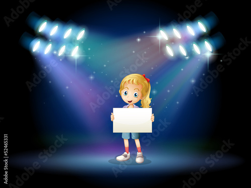 A stage with a young girl holding an empty signage