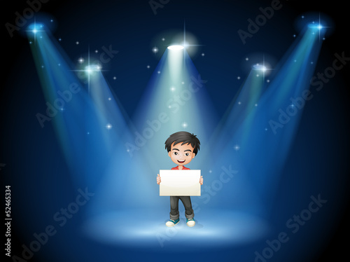 A boy holding an empty board with spotlights