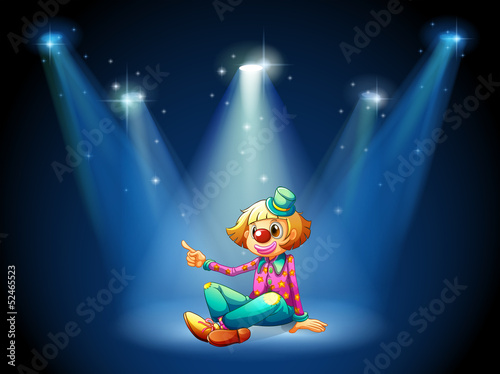 A stage with a female clown sitting at the center