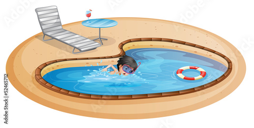 A boy swimming at the pool with a beach chair and table © GraphicsRF