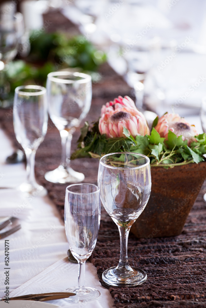 Wine and champagne glasses on a table with protea flowers Wine and champagne glasses on a table with protea flowers