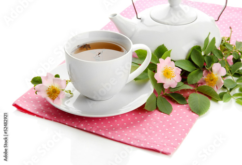 Cup and teapot of herbal tea with hip rose flowers, isolated