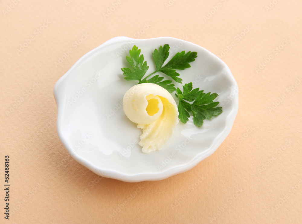Butter curl on plate on beige background Butter curl on plate on beige background