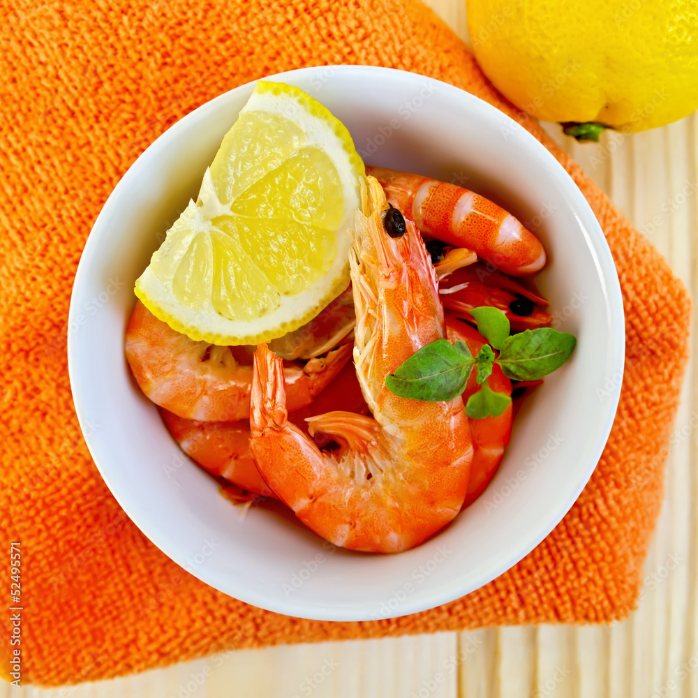 Shrimp in a white bowl on orange napkin Shrimp in a white bowl on orange napkin