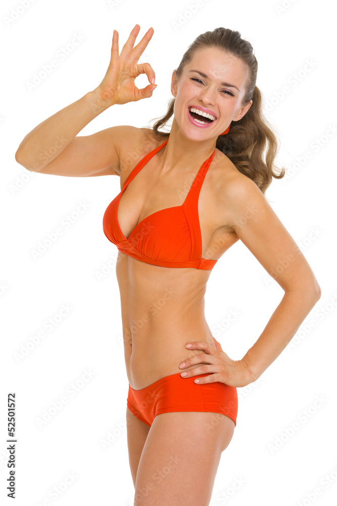 Smiling young woman in swimsuit showing ok gesture Smiling young woman in swimsuit showing ok gesture