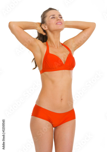 Happy young woman in swimsuit enjoying sunbathing