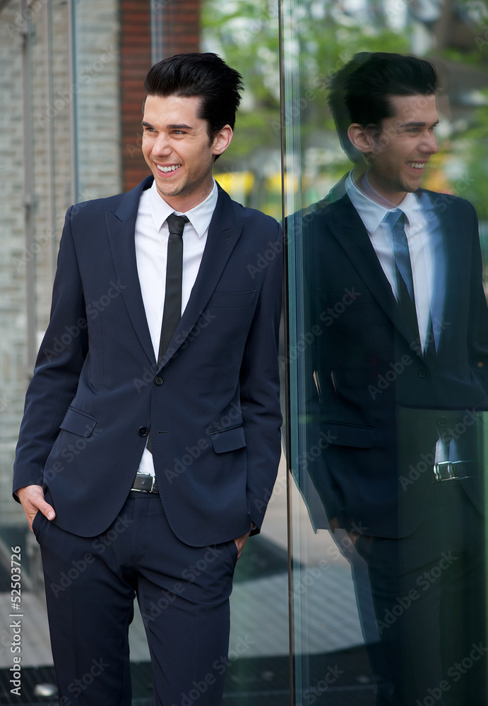 happy businessman leaning against glass building happy businessman leaning against glass building