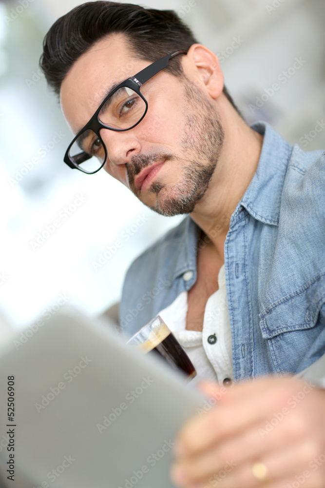 Middle-aged guy using digital tablet at home Middle-aged guy using digital tablet at home