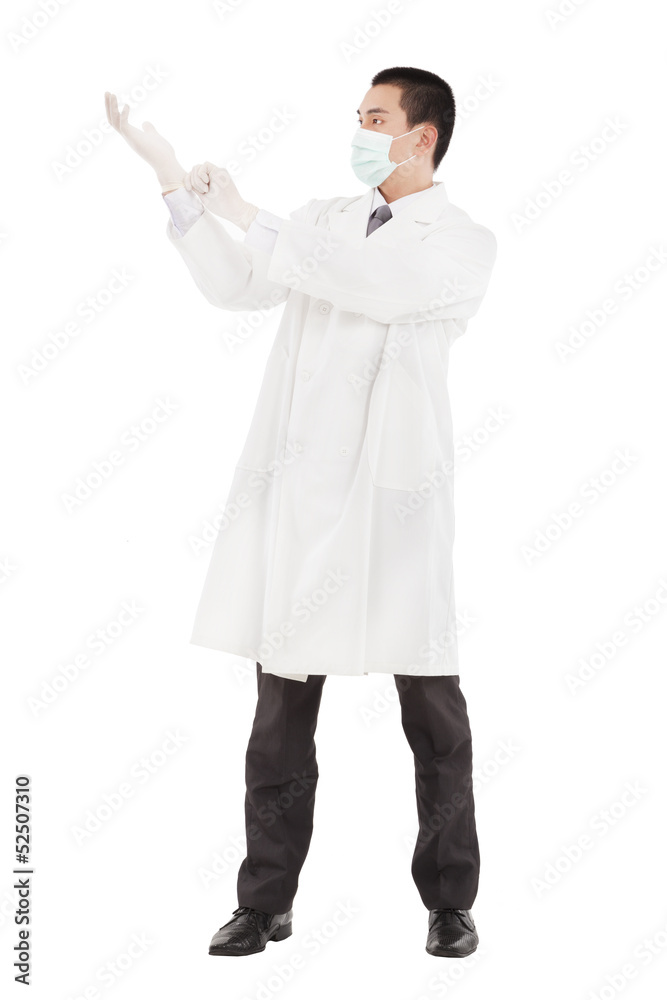 Young doctor standing and putting on his gloves Young doctor standing and putting on his gloves