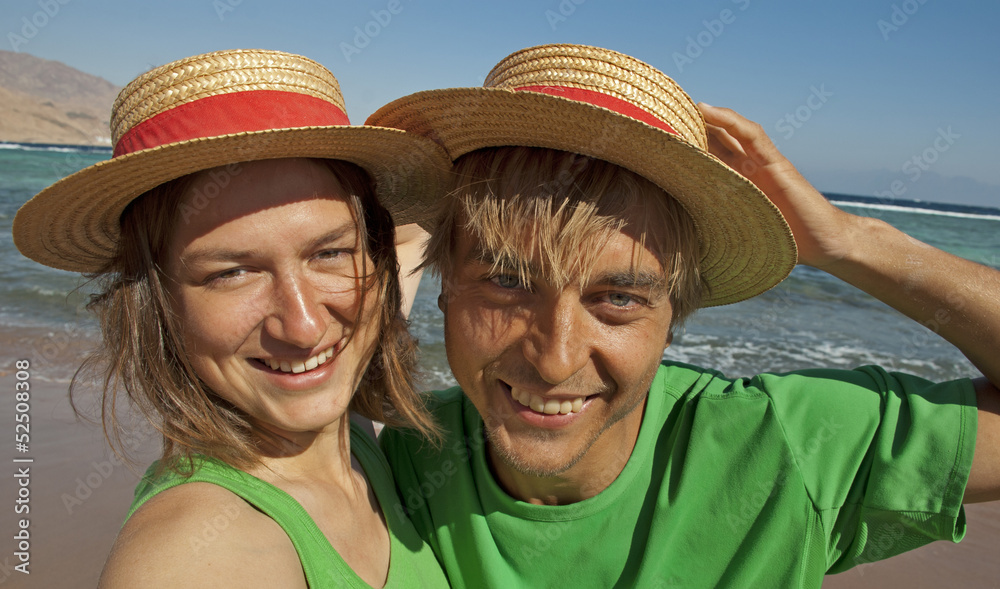 Funny couple in straw hats on sea resort