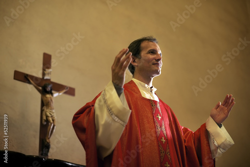 Tela Catholic priest on altar praying during mass