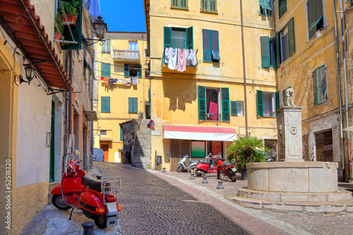 Small plaza among colorful houses in Ventimiglia, Italy.