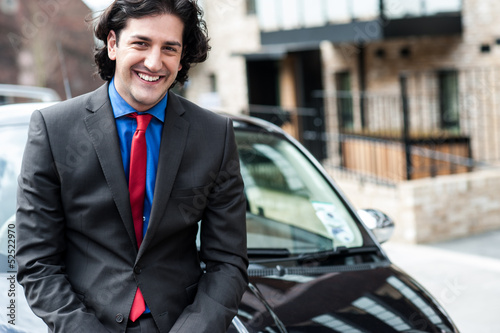 Handsome corporate man posing in front of his new car © stockyimages