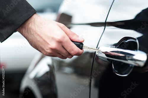 Man inserting car key into the door lock