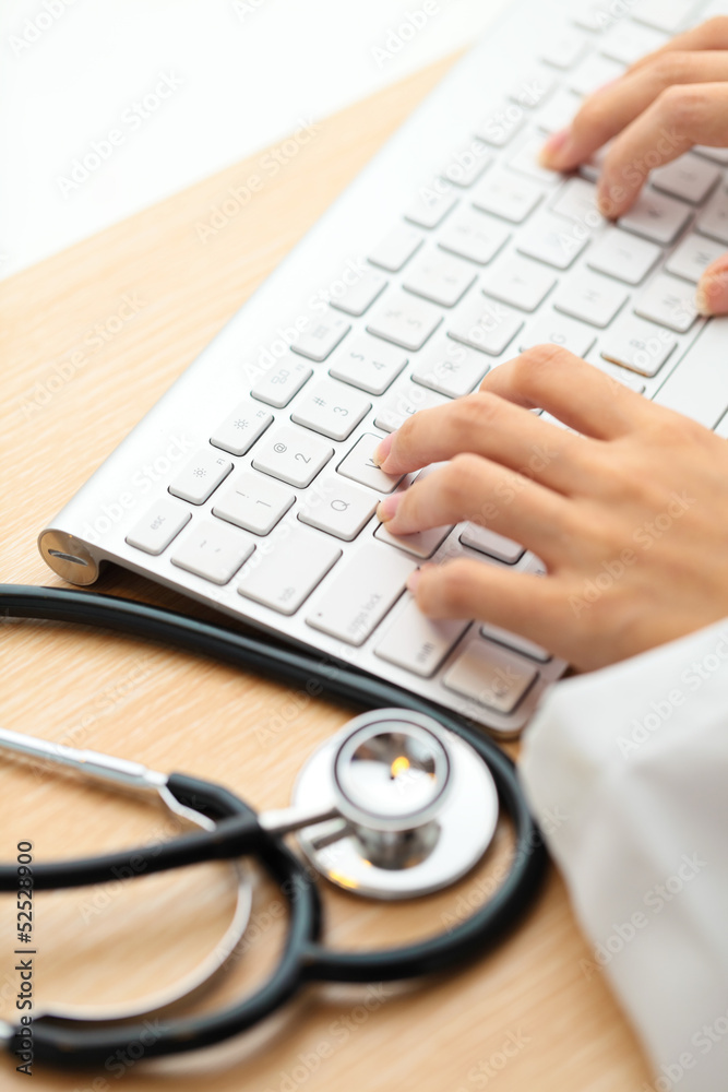 Doctor typing on keyboard with stethoscope Doctor typing on keyboard with stethoscope