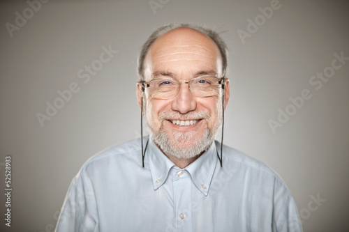 Portrait of old man taking glasses and smiling