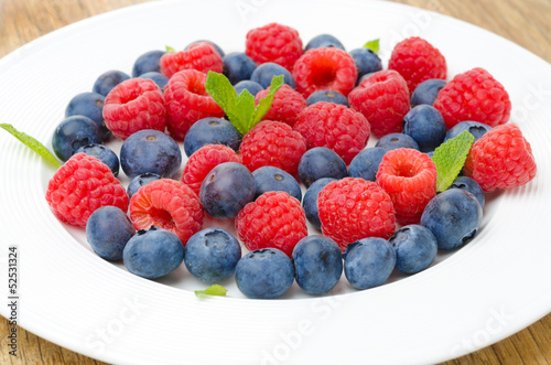 Fresh raspberries and blueberries on a plate