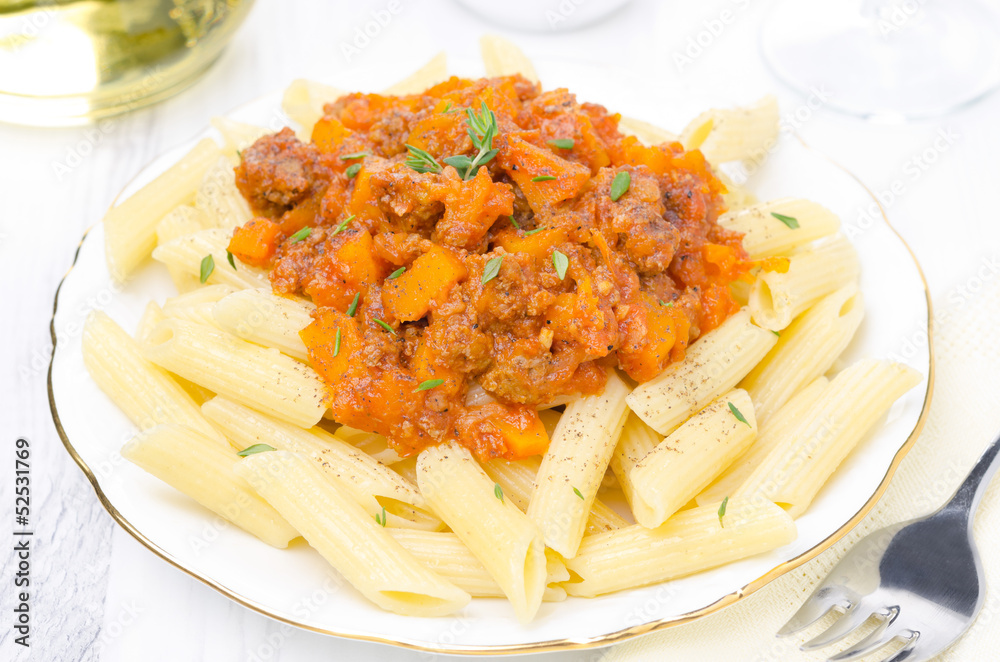 penne pasta with sauce of beef, tomato, pumpkin on a white plate penne pasta with sauce of beef, tomato, pumpkin on a white plate