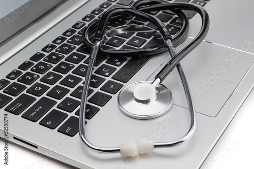 Medical stethoscope on a modern laptop, close-up. Isolated.