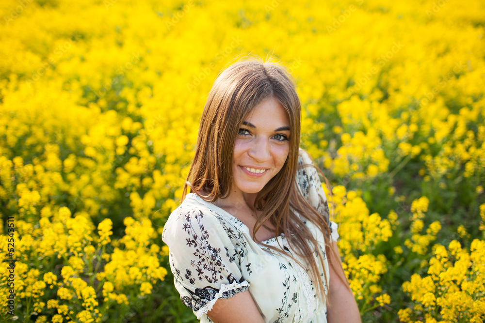 Beautiful woman among yellow flowers in a field Beautiful woman among yellow flowers in a field