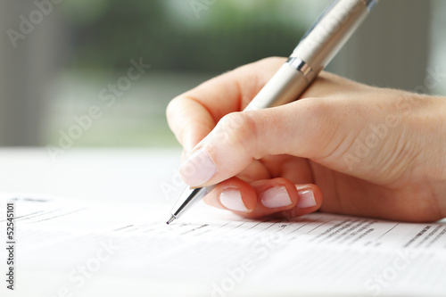 Businesswoman writing on a form
