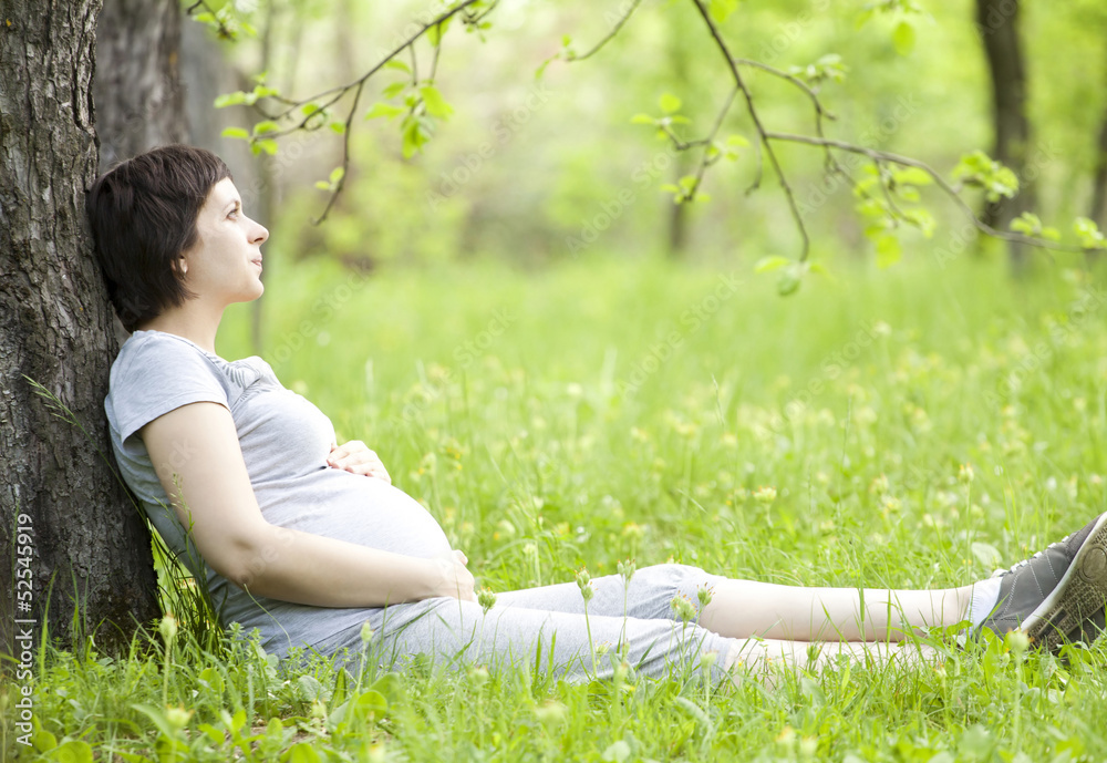 Pregnant woman relaxing in the park Pregnant woman relaxing in the park