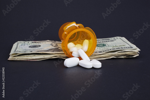 Photos Open Prescription Pill Bottle on a Stack of Money