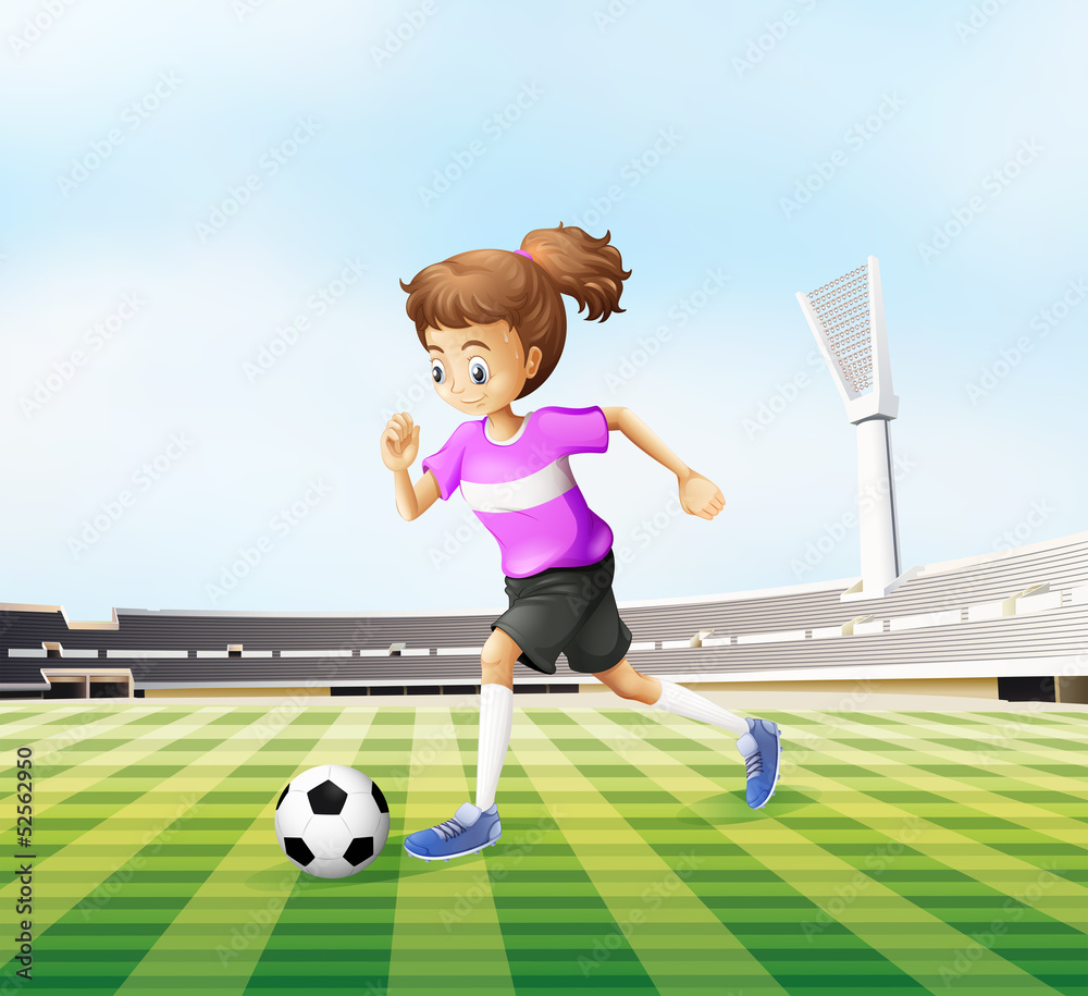 Fototapeta premium A young girl playing soccer at the field