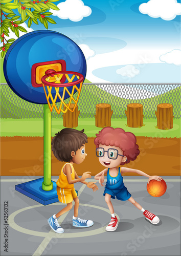 Two boys playing basketball at the basketball court
