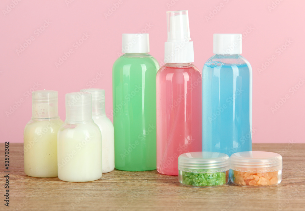 Hotel amenities kit on table on pink background Hotel amenities kit on table on pink background