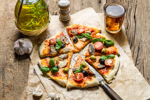 Homemade pizza served on old wooden table