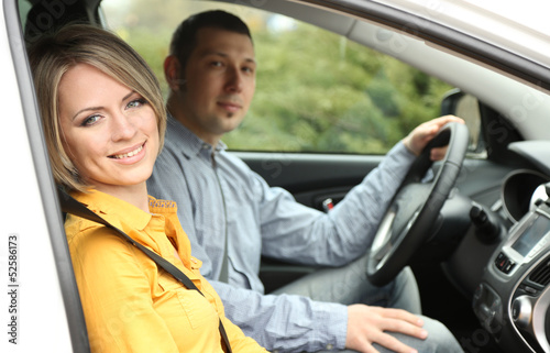 Portrait of young beautiful couple sitting in the car