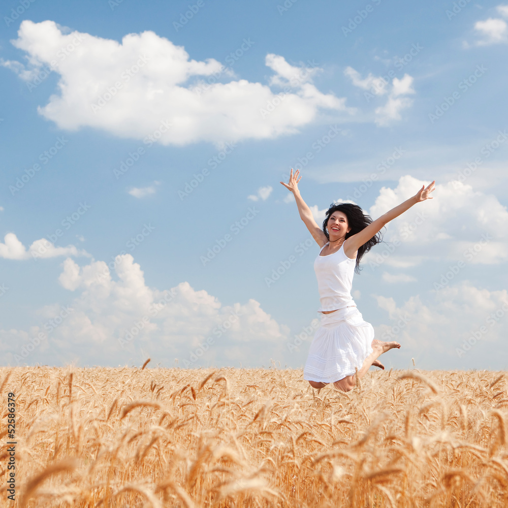 Happy woman jumping in golden wheat Happy woman jumping in golden wheat