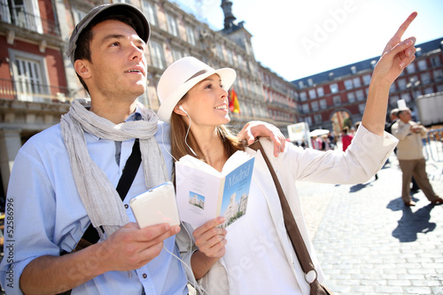 Fotografie Tourists walking in La Plaza Mayor with traveler guide