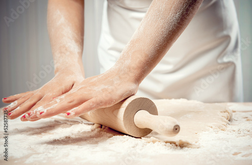 Woman rolling dough, close-up photo