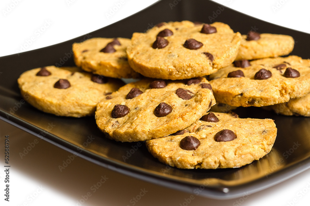 Chocolate chip cookies on a black plate isolated on white backgr