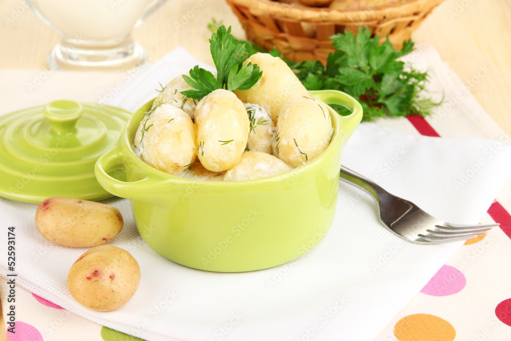 Tender young potatoes with sour cream and herbs in pan Tender young potatoes with sour cream and herbs in pan