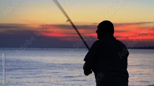 Angler fisherman trolling rod and reel fighting saltwater fish photo