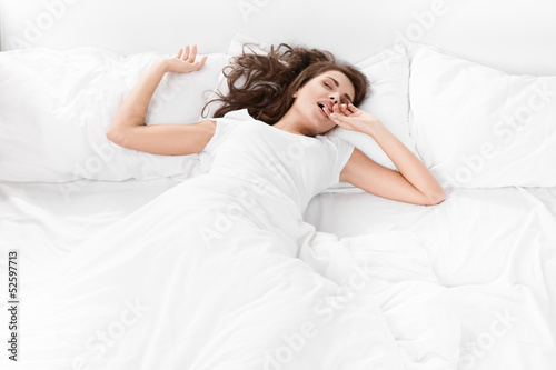 young woman sleeping on the white linen in bed