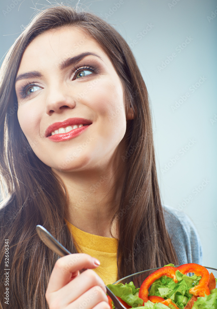 Woman eating green salad . Female model close up face studio is Woman eating green salad . Female model close up face studio is