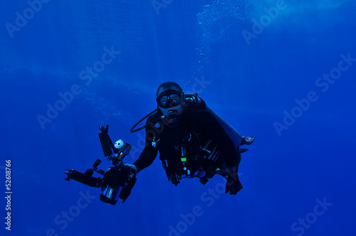 Underwater photographer with big camera and flashes