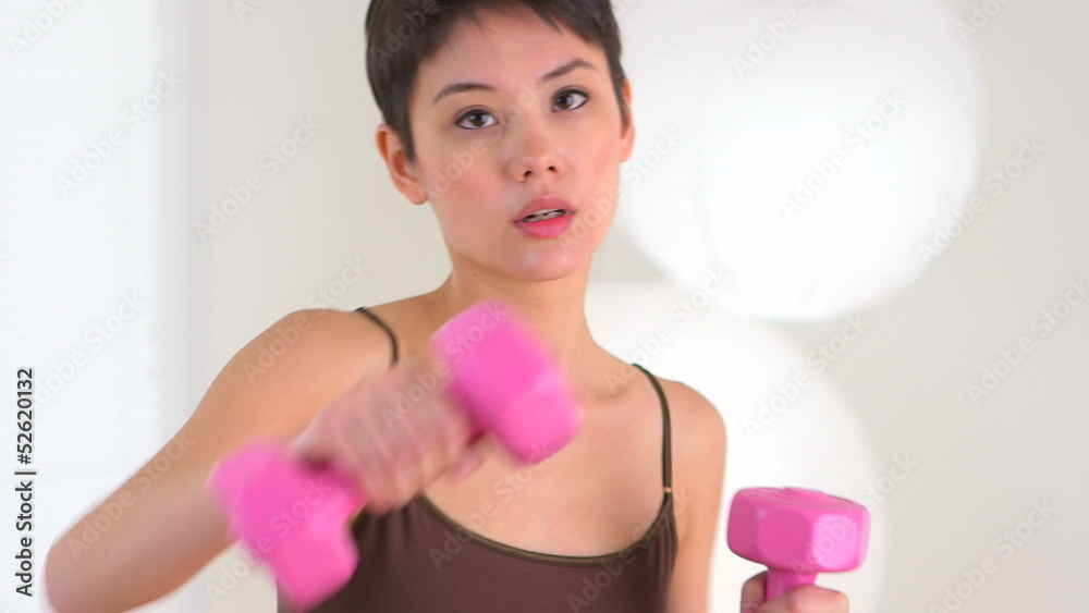 Chinese woman punching while holding weights Chinese woman punching while holding weights