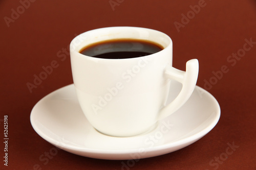 Cup of strong coffee on brown background