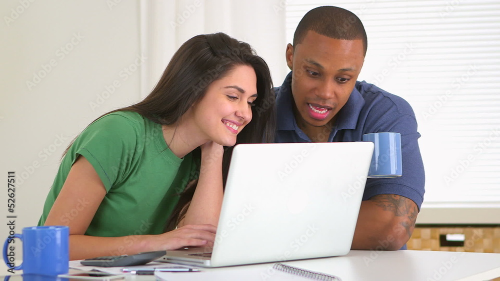 African american and caucasian couple paying bills together African american and caucasian couple paying bills together