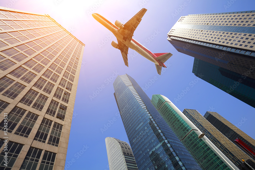 Look up at aircraft is flying modern urban office buildings in S