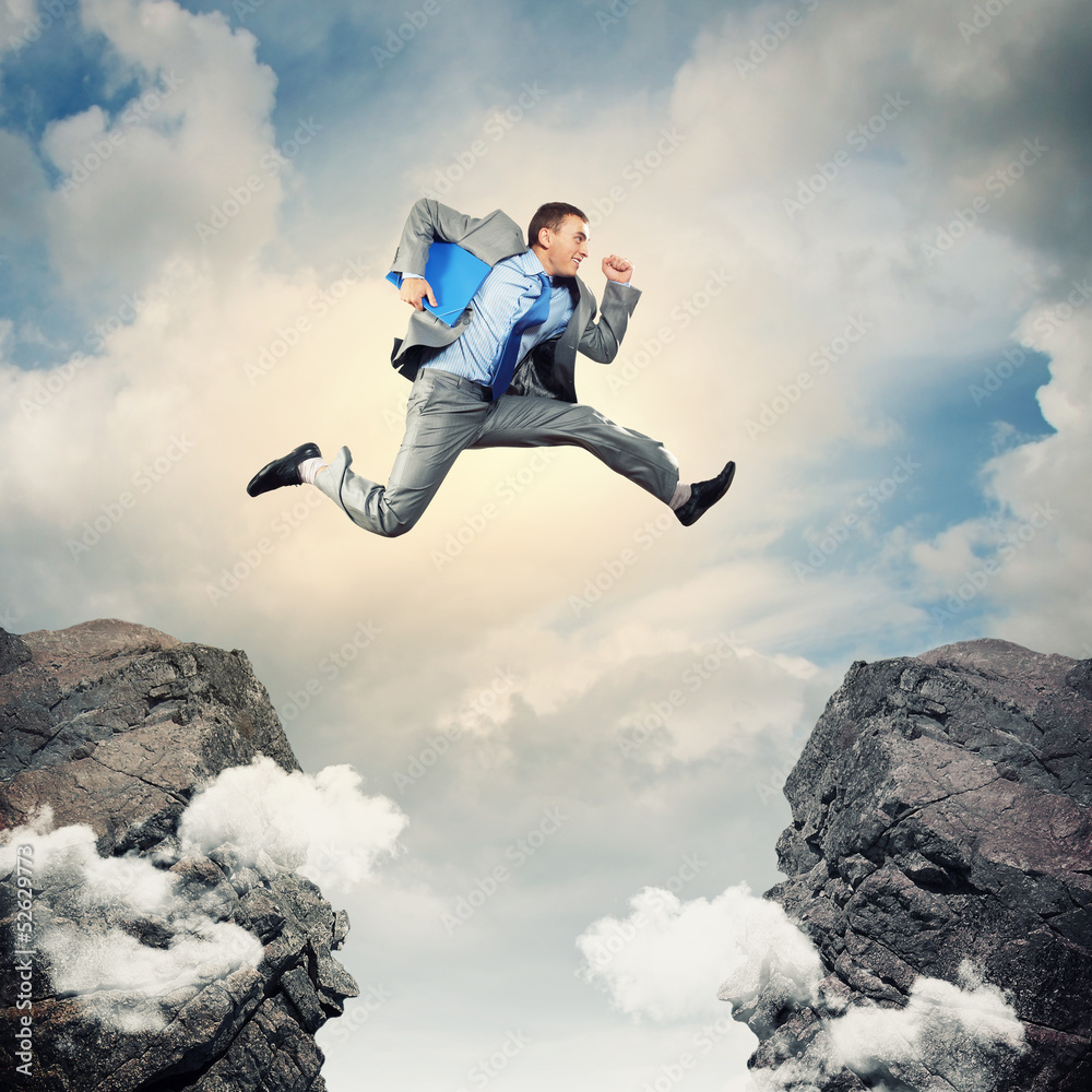 Businessman jumping over gap