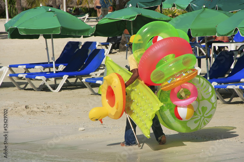 Man walking with swim matresses and rings, Boca Chica beach photo